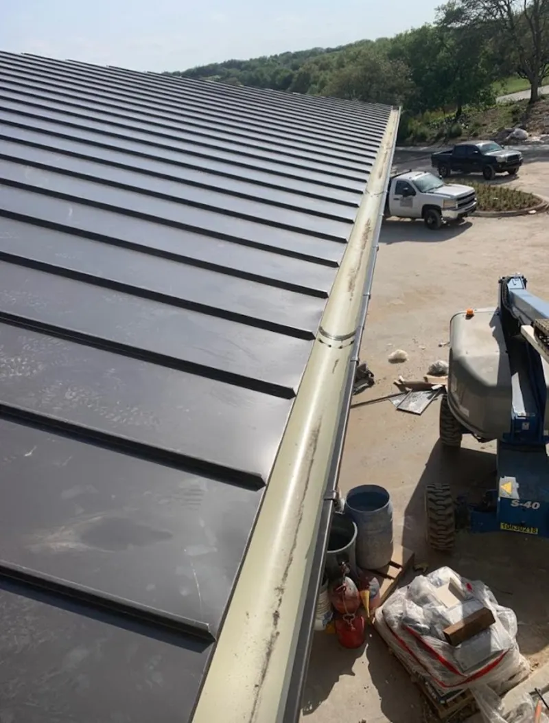 Standing seam panel and gutter detail on a metal roofing jobsite in Greenfield